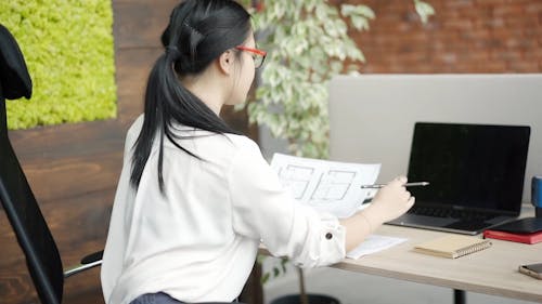 Woman Writing Notes while Working in the Office