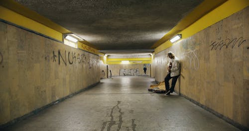 Man Playing Guitar in Underpass