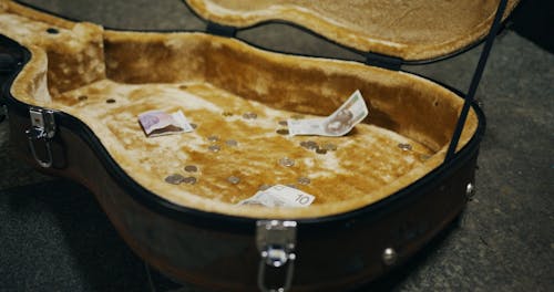 Paper Bills and Coins on the Guitar Case