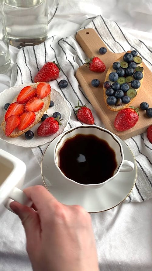 Person Pouring Milk into a Cup