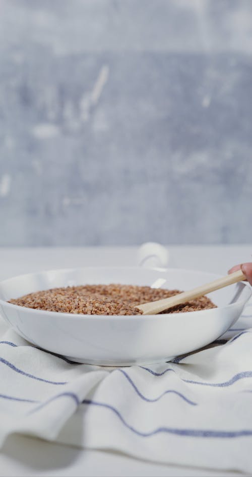 A Woman Scooping Some Nuts From the Bowl