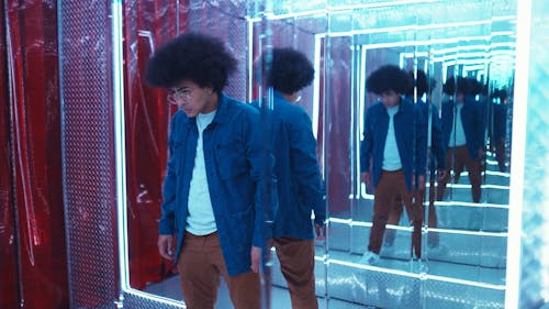 A Young Man Dancing in Front of a Mirror