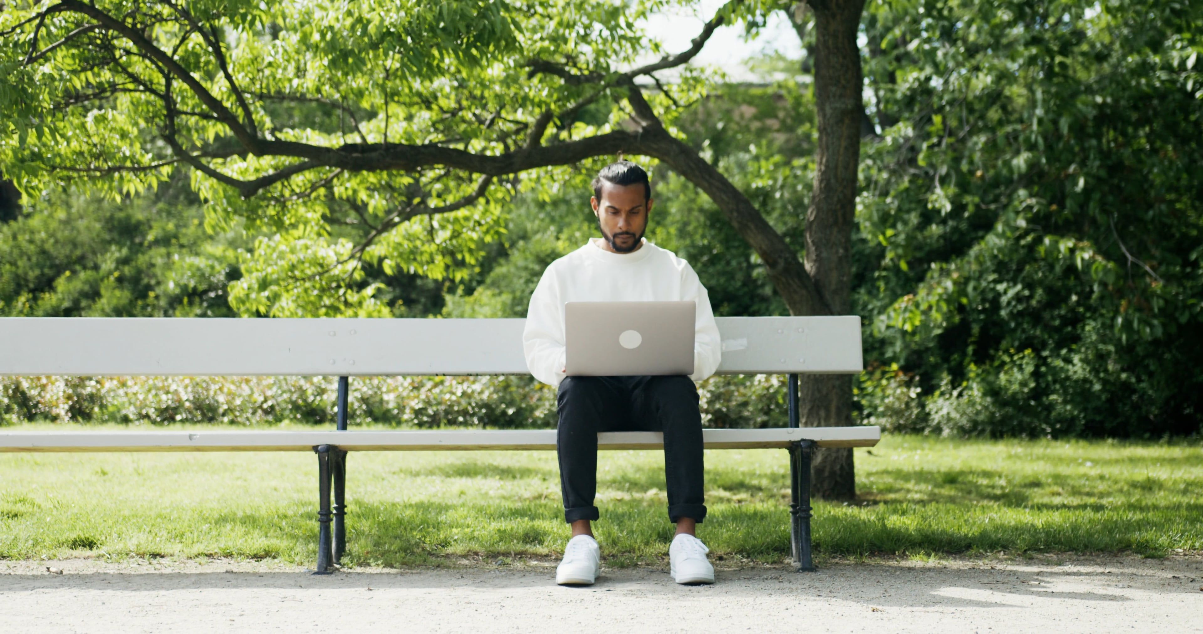 A Man Using a Laptop while Sitting on a Bench · Free Stock Video
