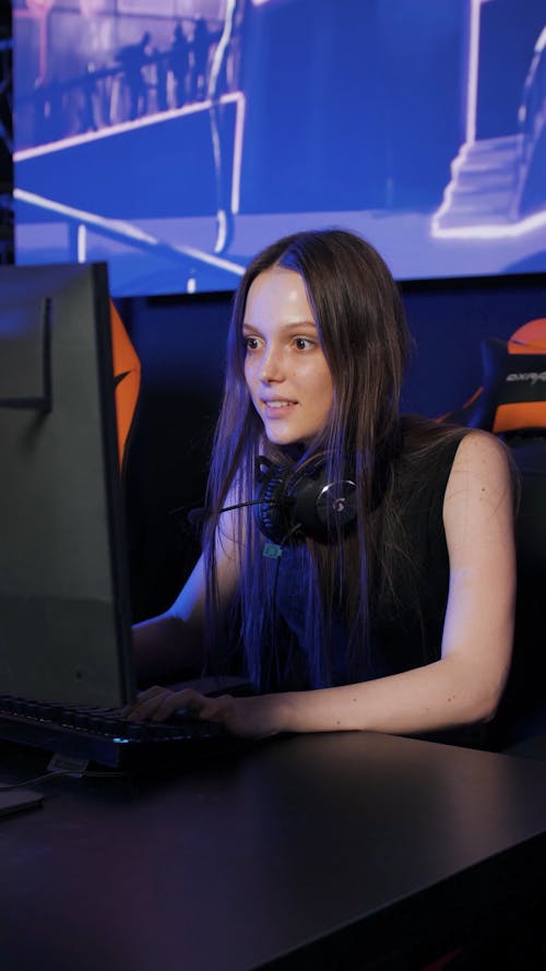 A Young Woman Cheering while Playing a Computer Game