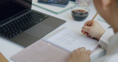 A Person Writing on a Paper Then Crumpling and Throwing it