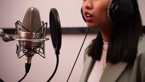 Woman Singing on the Studio using Condenser Microphone