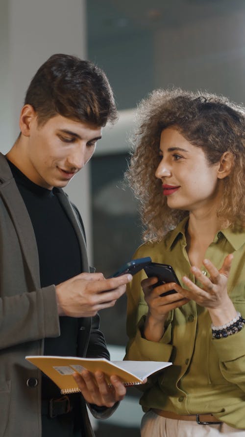 Workmates Browsing On Mobile Phone