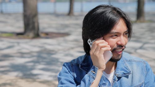 Man with Facial Hair Talking on the Phone