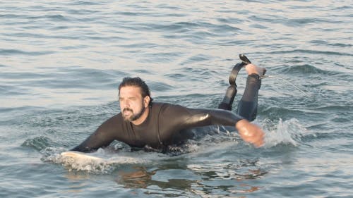 Man Paddling on Surfboard