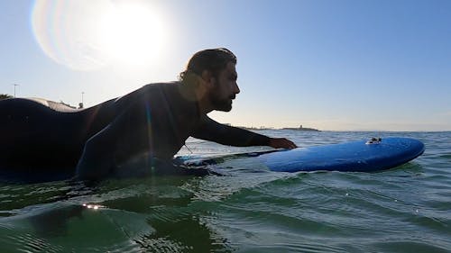 Man Paddling on a Surfboard