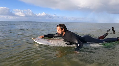 Man Paddling on a Surfboard