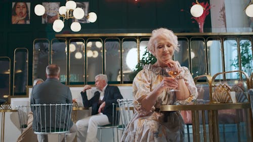 An Elderly Woman Drinking a Wine
