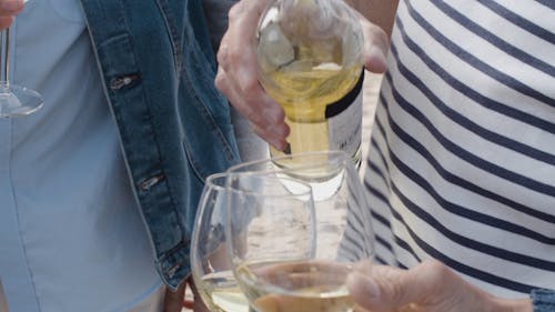 A Person Pours Wine in a Wine Glass