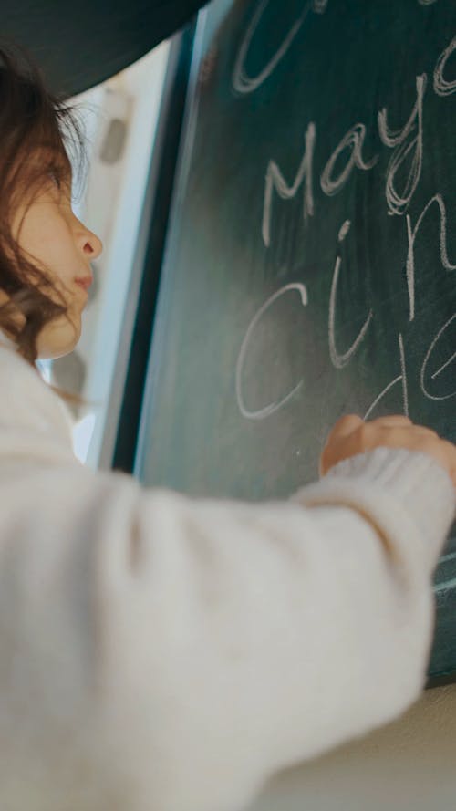 Little Girl Writing on a Blackboard
