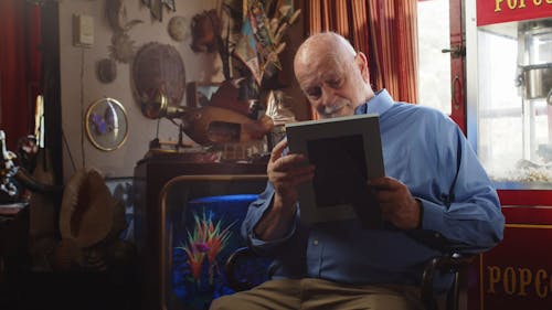 An Elderly Man Looking at a Picture Frame