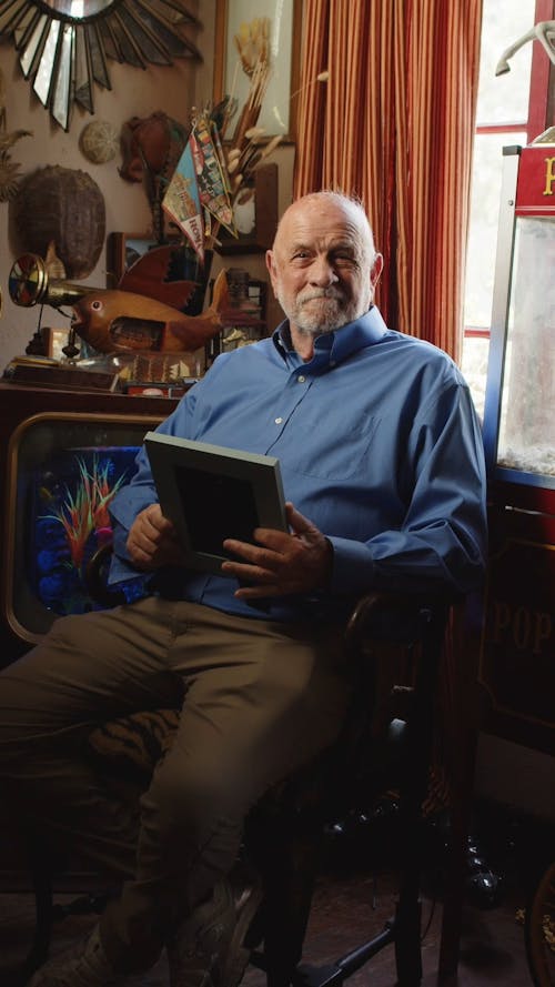 An Elderly Man Looking at a Picture Frame