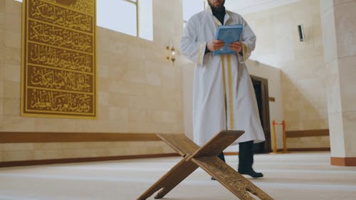 A Man Carrying a Quran Book
