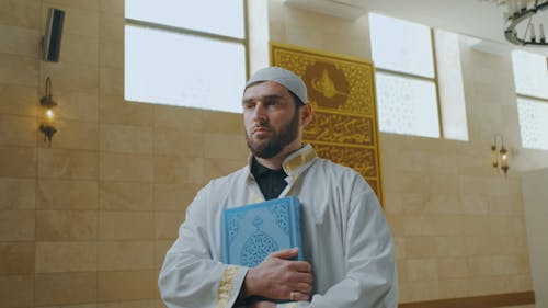 A Man Holding a Quran