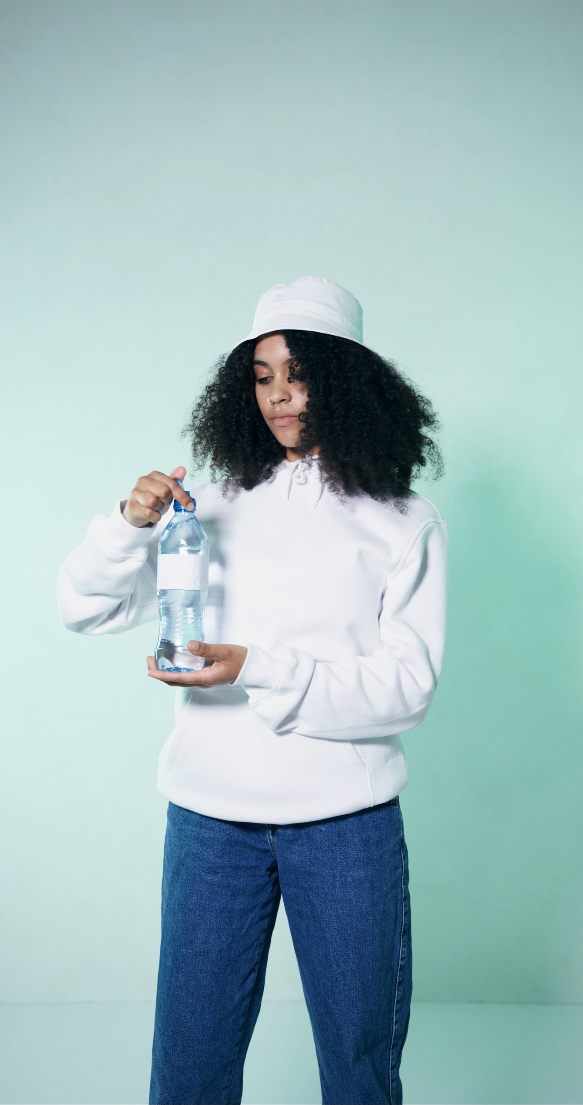 A Woman Holding a Bottle of Water while Looking at a Camera · Free ...