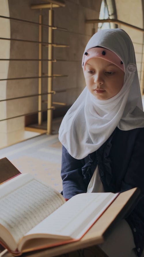 A Girl Praying and Reading the Quran