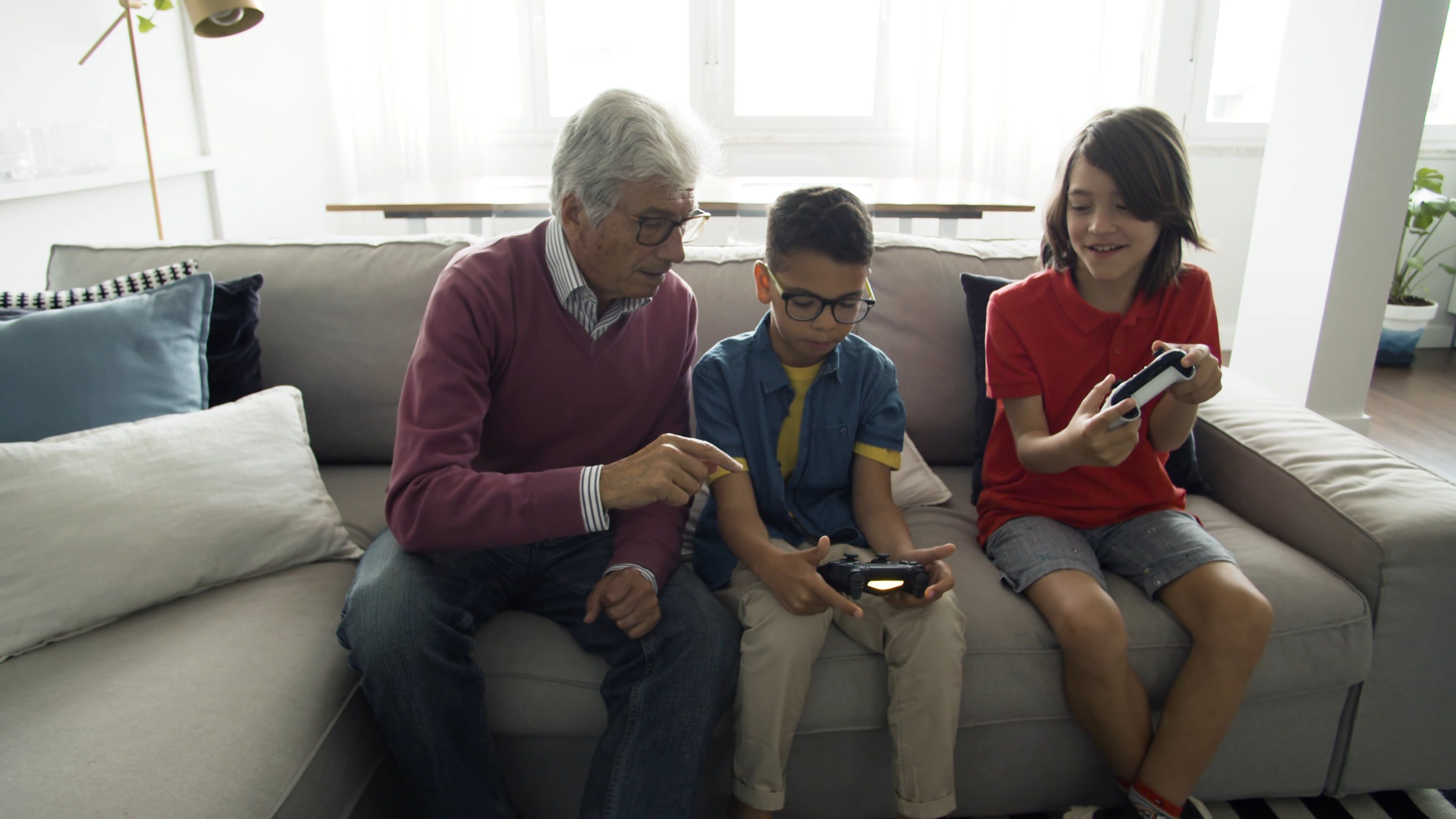 Elderly Man Teaching a Child How to Use a Wireless Game Controller ...
