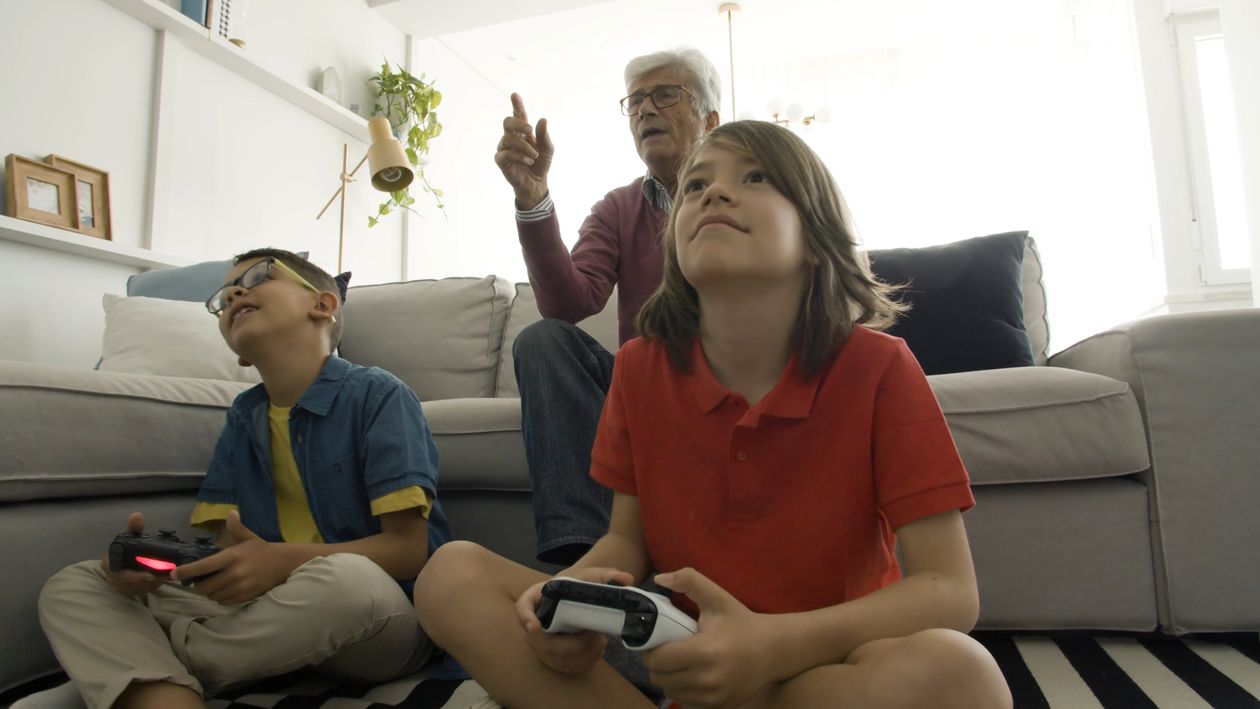 Grandfather Watching His Grandchildren Play Video Games Free Stock ...
