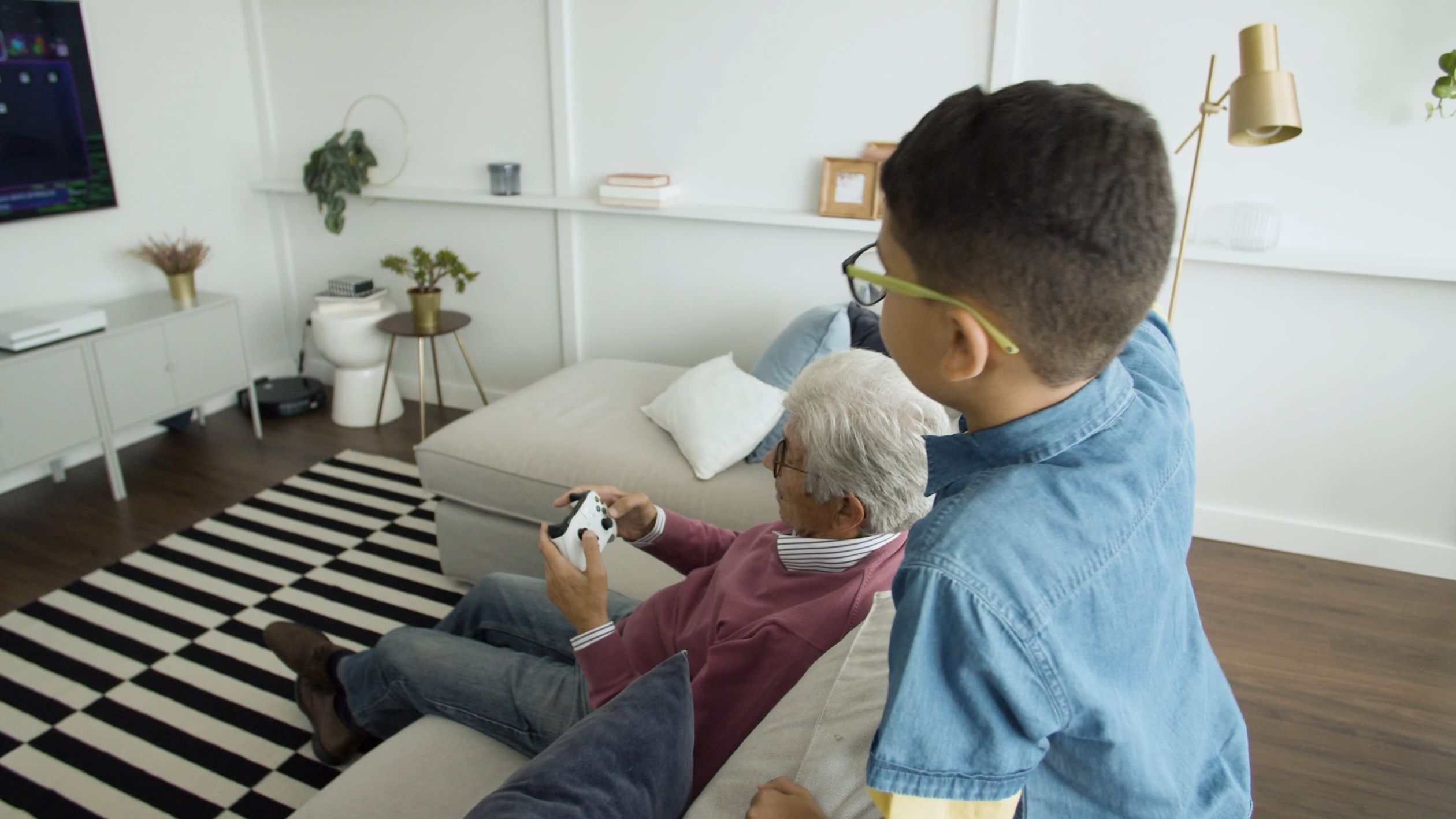 A Boy Teaching his Grandfather How to Play a Video Game Free Stock ...