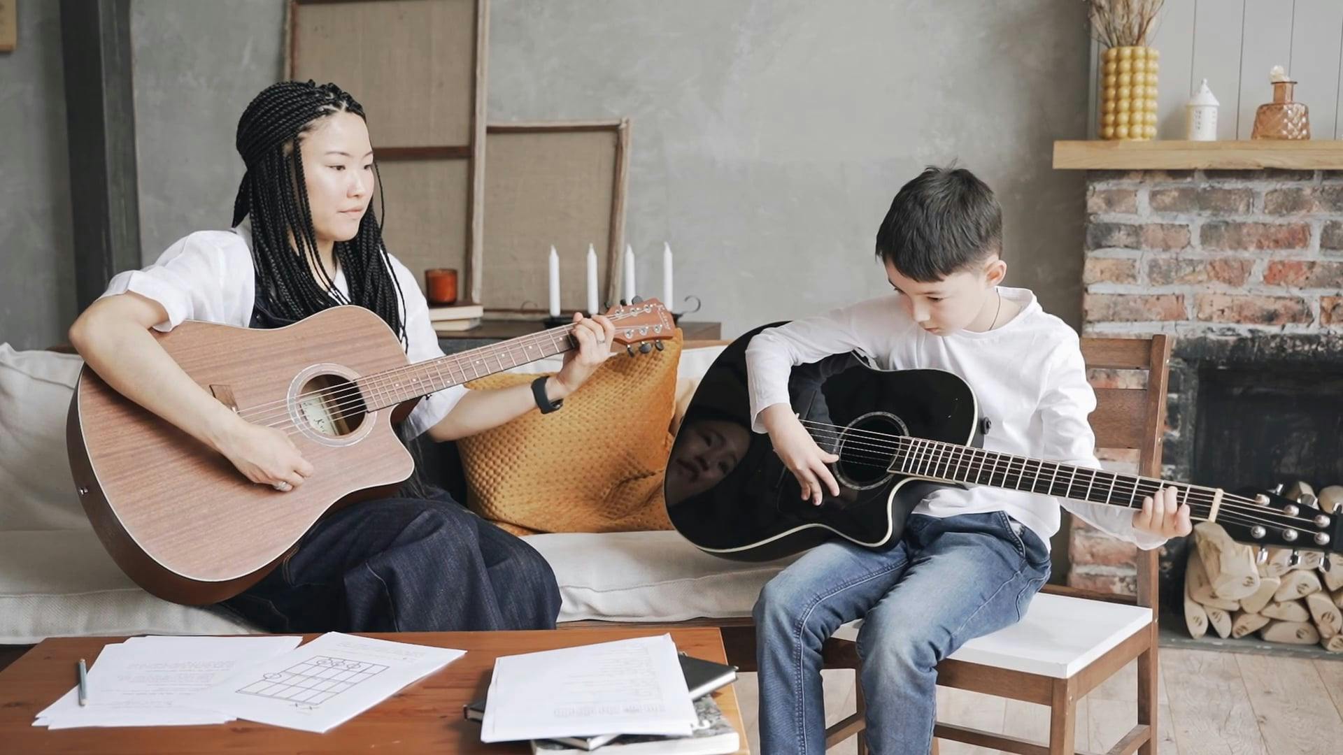 Mother Teaching her Son on How to Play a Acoustic Guitar Free Stock