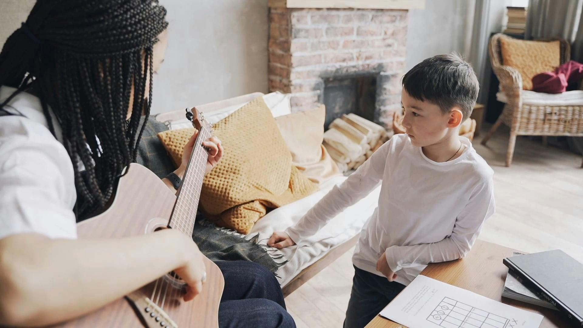 Mother Showing Her Son on How to Play a Acoustic Guitar Free Stock