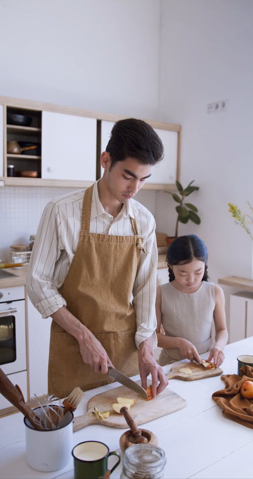 Man Slicing Fruits with His Daughter