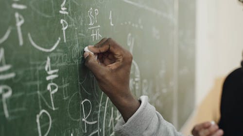 Man Writing Algebra In The Chalkboard