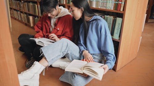 Students Reading Book In The Library