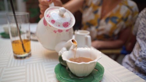 A Person Pouring Drink on the Cup