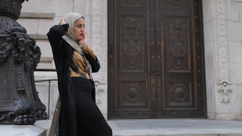 A Woman Posing On A Building Facade