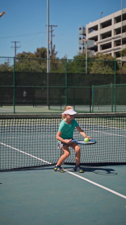 A Girl Bouncing Tennis Ball Off Her Racket