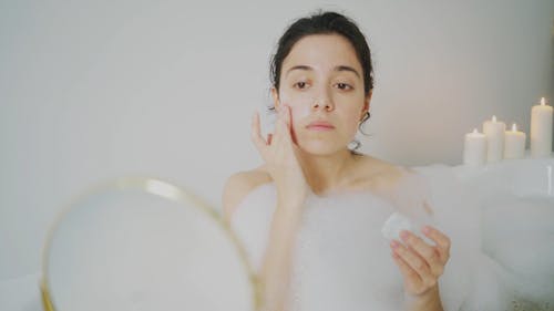 A Woman Putting Cream on Her Face