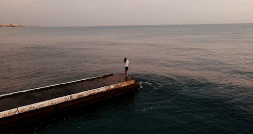 A Woman Standing on Sea Dock