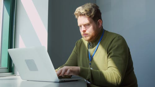 A Man Working while Using His Laptop