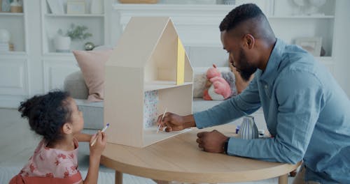 Father and Daughter Painting a Dollhouse Together