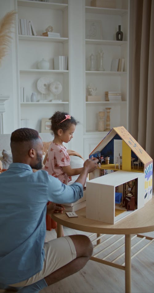 Father and Daughter Playing Dollhouse Together