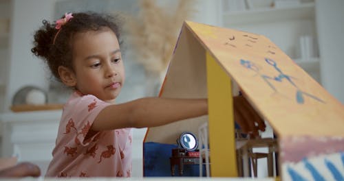 Father and Daughter Playing Dollhouse Together