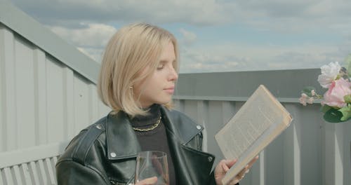 Woman Drinking Wine While Reading a Book 