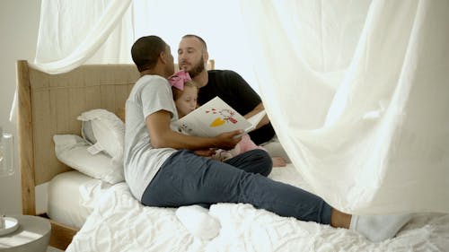 Men Sitting on Bed Kissing