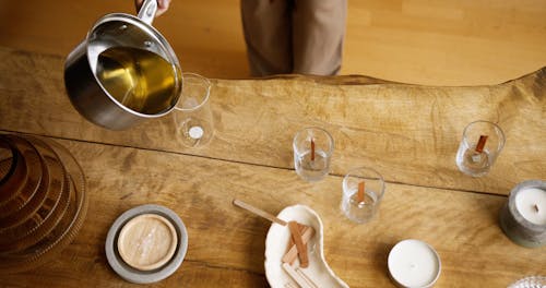 A Person Pouring Liquid Wax into a Glass Beaker