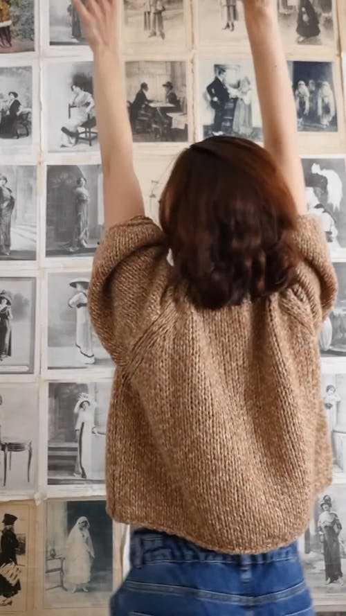 A Woman Dancing in Front of a Wall of Black and White Photos