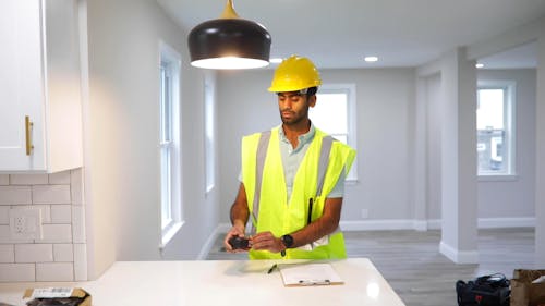 A Man Measuring Height of Ceiling