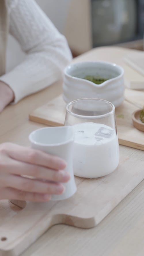 Woman Pouring Milk on the Glass