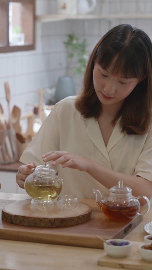 A Woman Pouring Tea on the Teacups