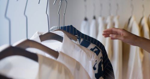 A Person Touching Clothes in a Shop