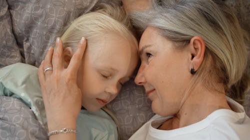 A Woman Lying in Bed with Her Granddaughter